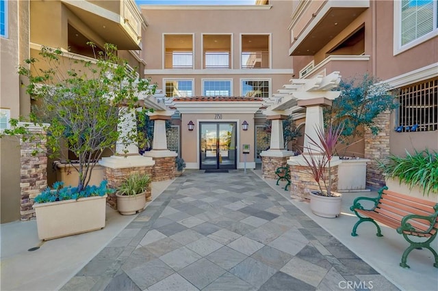 entrance to property featuring french doors and stucco siding