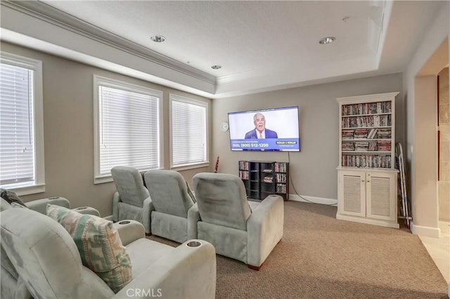 carpeted home theater room featuring ornamental molding and baseboards