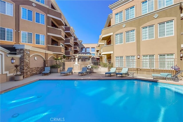 community pool featuring fence and a patio