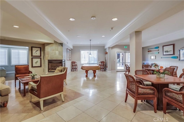 interior space with a tiled fireplace, ornamental molding, light tile patterned flooring, and recessed lighting