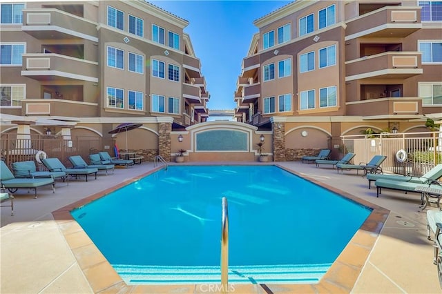 view of pool with a patio area and fence