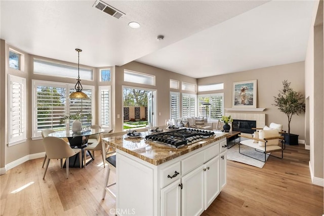 kitchen featuring visible vents, light wood finished floors, white cabinetry, and stainless steel gas cooktop