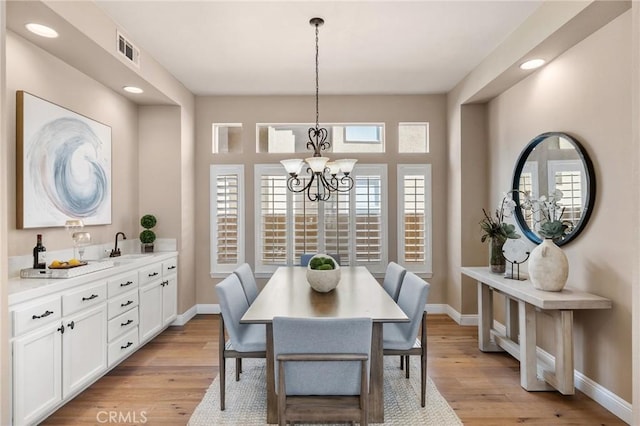 dining space with visible vents, baseboards, and light wood finished floors