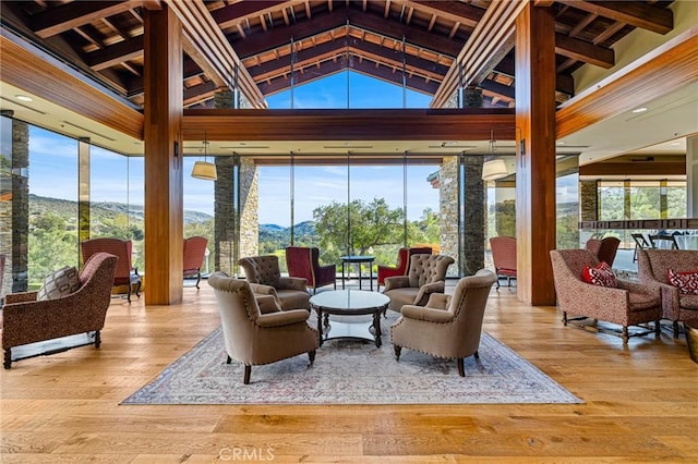 sunroom / solarium with vaulted ceiling, a mountain view, and a wealth of natural light