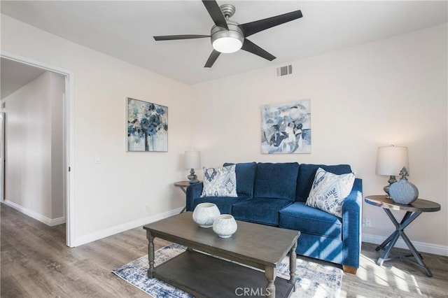 living room with a ceiling fan, baseboards, visible vents, and wood finished floors