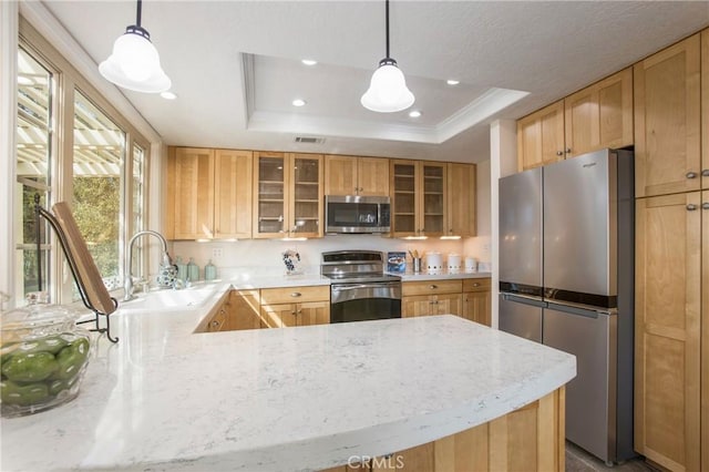 kitchen with visible vents, a raised ceiling, glass insert cabinets, appliances with stainless steel finishes, and a sink