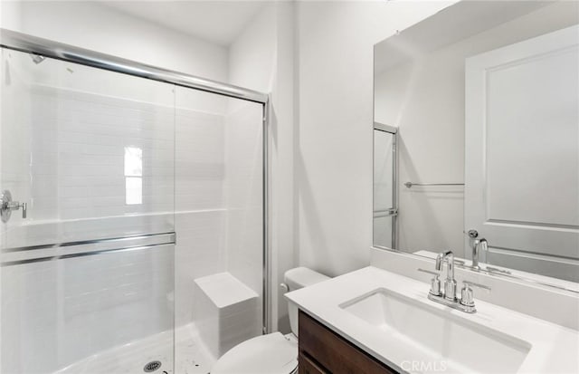 bathroom featuring a shower stall, toilet, and vanity