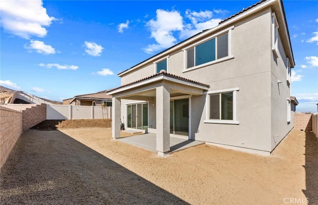 rear view of property with a patio area, a fenced backyard, and stucco siding