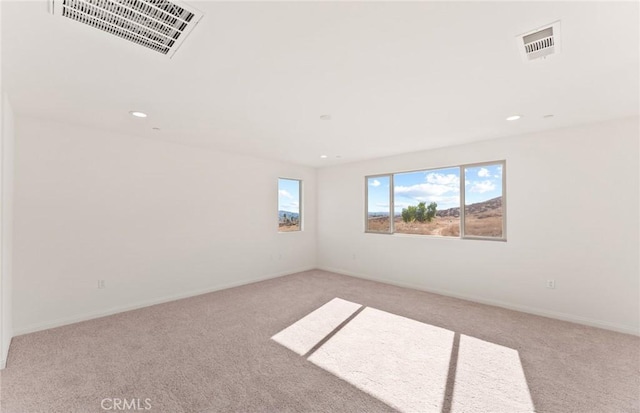 empty room with carpet floors, baseboards, visible vents, and recessed lighting