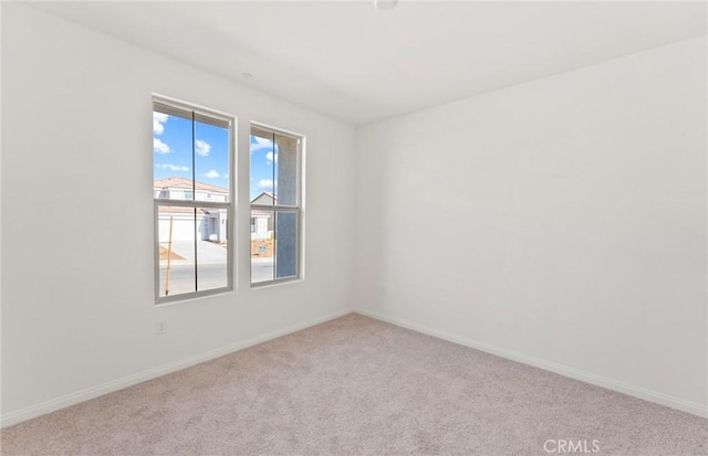 spare room with carpet floors and baseboards