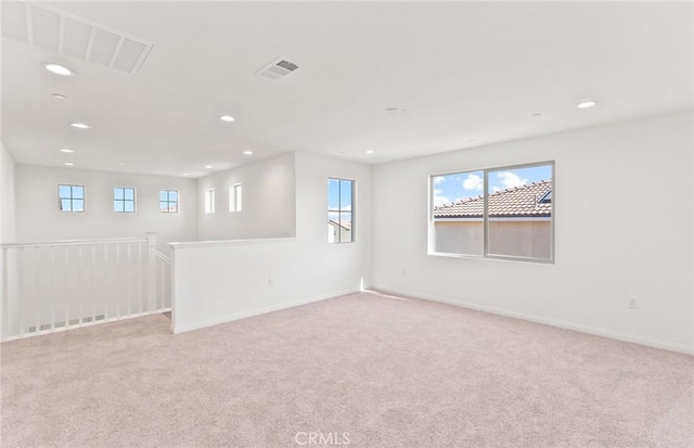 spare room featuring light carpet, baseboards, visible vents, and recessed lighting