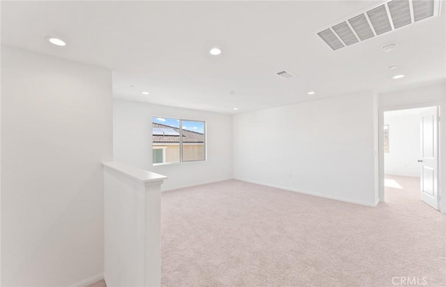 spare room with light carpet, baseboards, visible vents, and recessed lighting