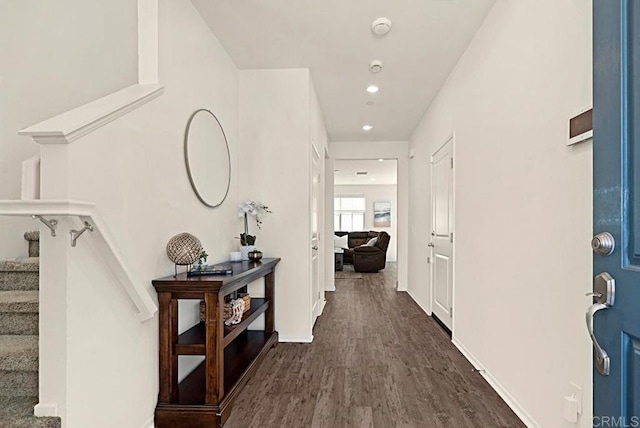 hall featuring recessed lighting, dark wood finished floors, baseboards, and stairs