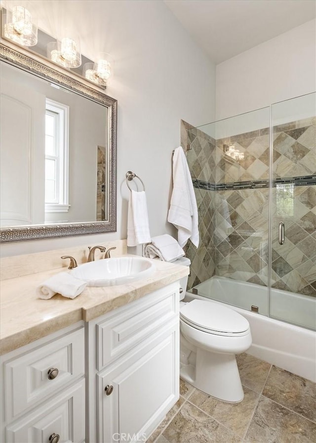 bathroom featuring shower / bath combination with glass door, vanity, and toilet