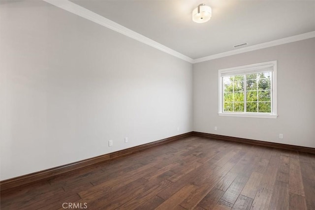 empty room with ornamental molding, dark wood-style flooring, visible vents, and baseboards