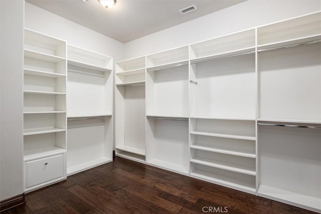 spacious closet featuring dark wood-type flooring and visible vents