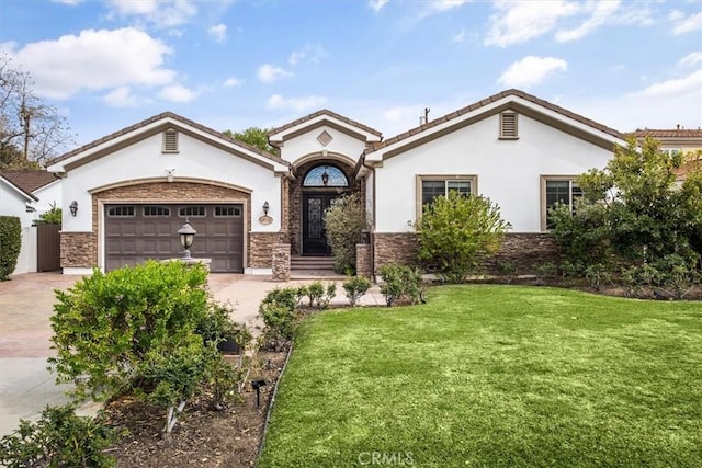 mediterranean / spanish-style home featuring a garage, stone siding, driveway, stucco siding, and a front yard