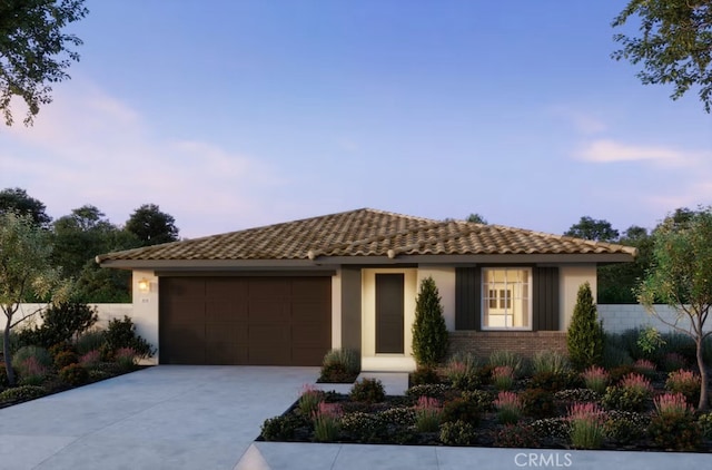 view of front of house with an attached garage, fence, driveway, a tiled roof, and stucco siding