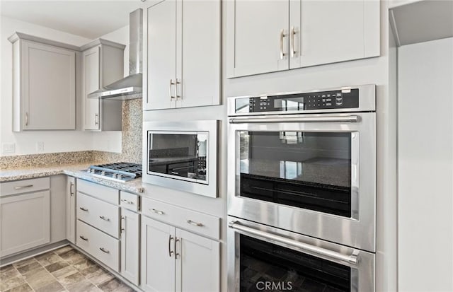 kitchen with appliances with stainless steel finishes and wall chimney exhaust hood