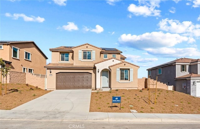 mediterranean / spanish-style house featuring a tiled roof, fence, driveway, and stucco siding