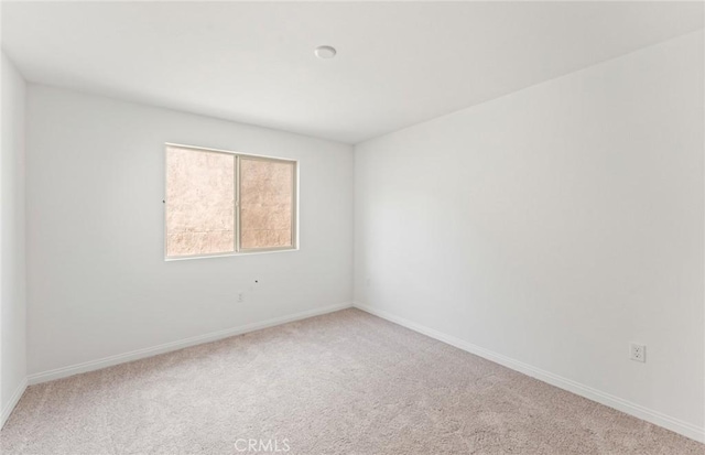 carpeted empty room with baseboards