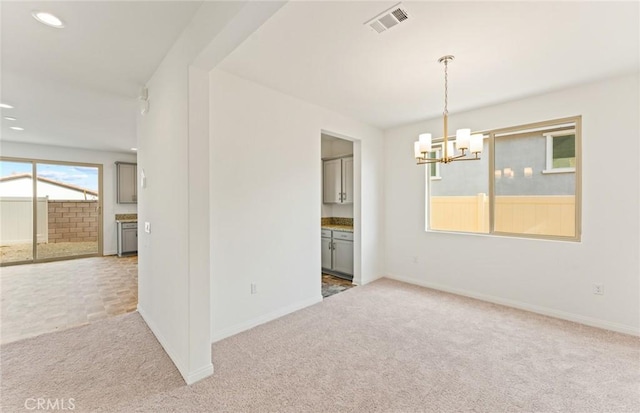 spare room featuring a chandelier, recessed lighting, visible vents, baseboards, and carpet