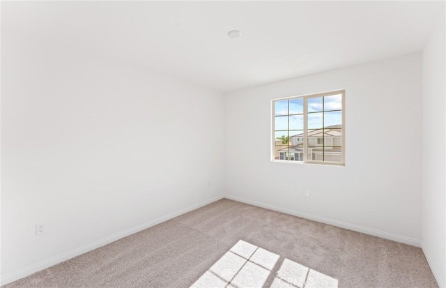 spare room with carpet flooring and baseboards