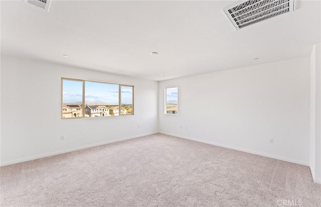 carpeted empty room with visible vents and baseboards