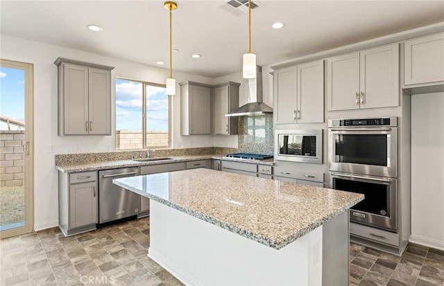 kitchen featuring wall chimney exhaust hood, visible vents, appliances with stainless steel finishes, and gray cabinetry