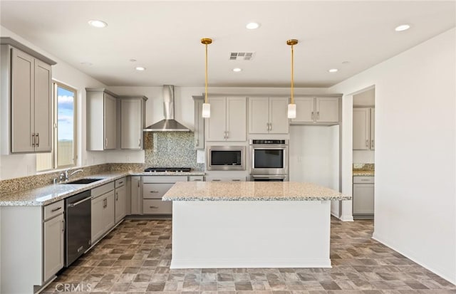 kitchen with visible vents, wall chimney exhaust hood, appliances with stainless steel finishes, gray cabinetry, and a sink