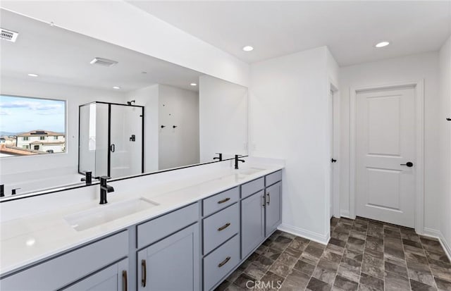 bathroom featuring recessed lighting, a sink, and a shower stall