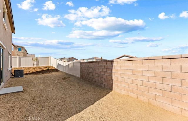 view of yard featuring a fenced backyard and central AC