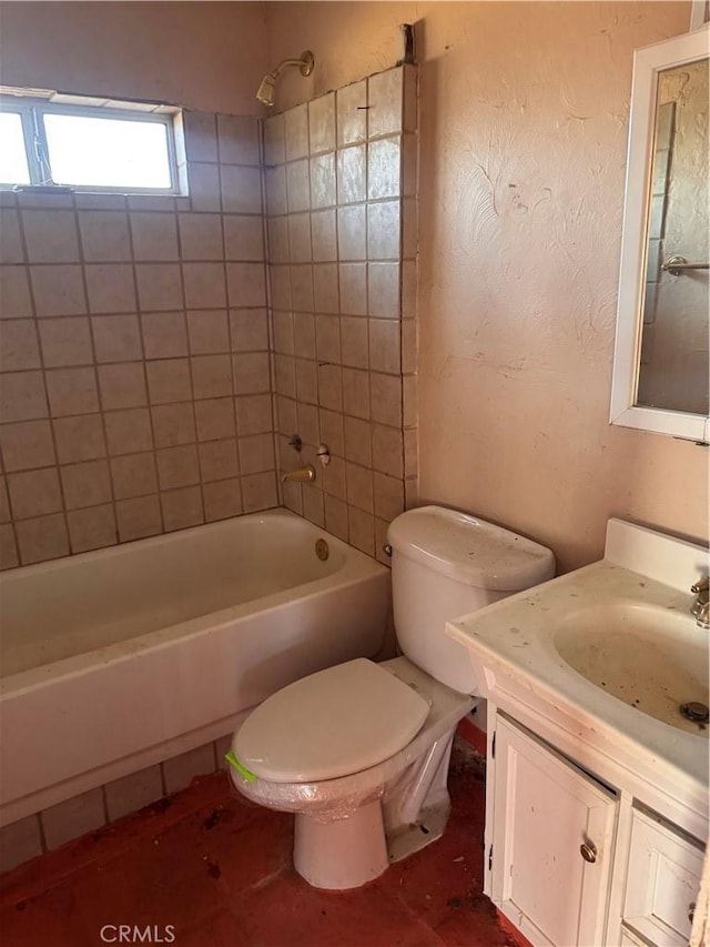 full bathroom featuring tub / shower combination, toilet, vanity, and a textured wall