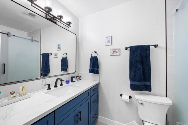 bathroom featuring toilet, a shower with shower door, visible vents, vanity, and baseboards