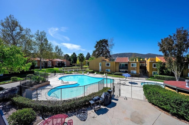 pool with a residential view, a patio area, and fence