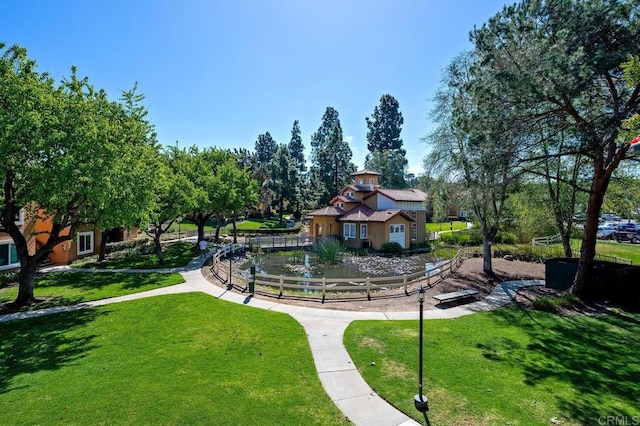 surrounding community with fence and a lawn