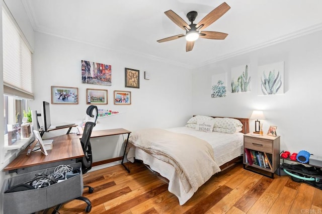 bedroom with wood-type flooring, ornamental molding, and ceiling fan