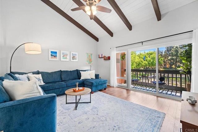 living area featuring a ceiling fan, high vaulted ceiling, beam ceiling, and wood finished floors