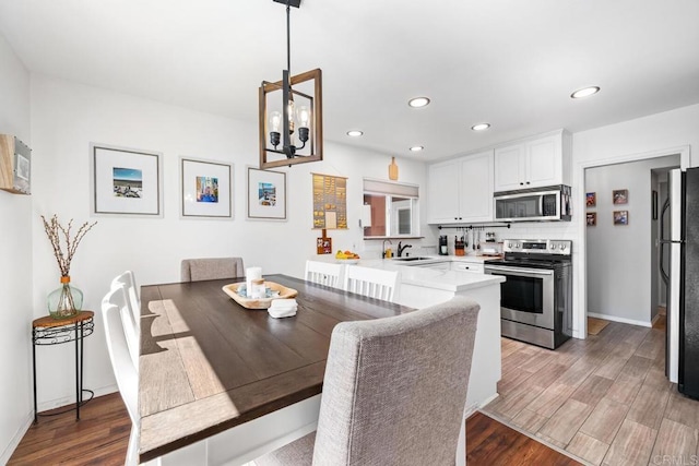 dining room with a chandelier, recessed lighting, baseboards, and light wood finished floors