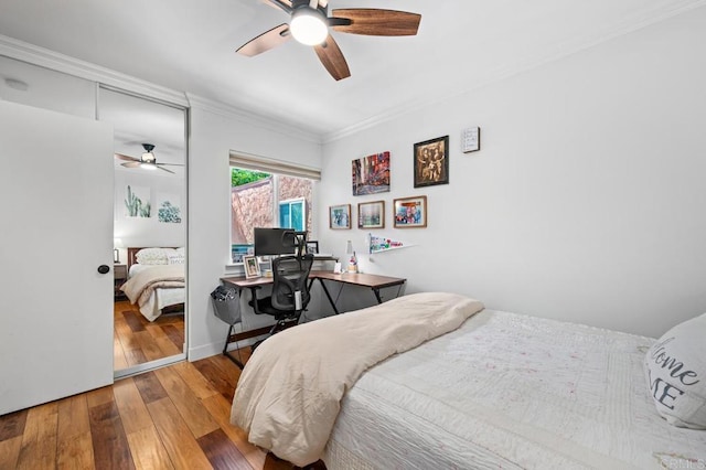 bedroom featuring ceiling fan, a closet, wood-type flooring, and crown molding