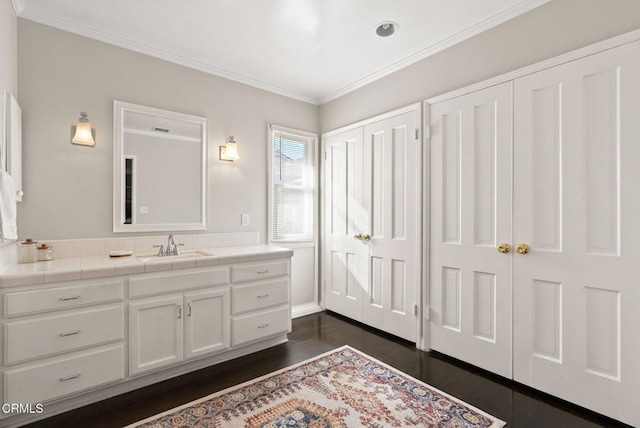 bathroom with vanity, wood finished floors, and ornamental molding