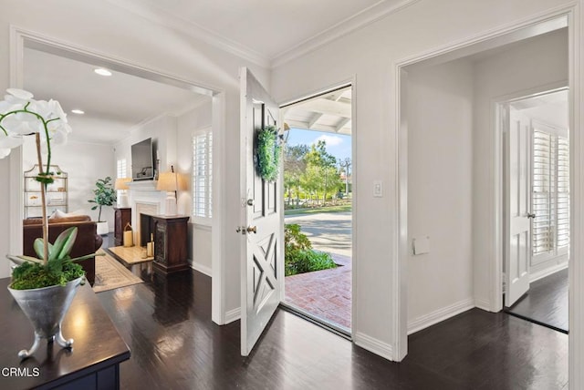 entrance foyer featuring baseboards, dark wood finished floors, ornamental molding, recessed lighting, and a fireplace