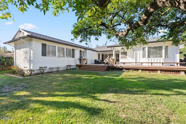 rear view of property featuring crawl space, a wooden deck, and a yard