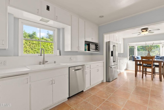 kitchen featuring light countertops, white cabinets, appliances with stainless steel finishes, and a sink