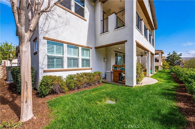 exterior space with a yard, a patio, and stucco siding