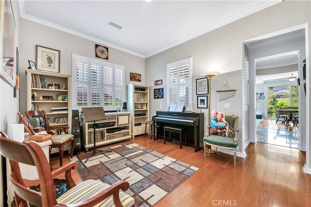 sitting room featuring visible vents, ornamental molding, and wood finished floors