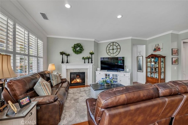 living area with ornamental molding, a fireplace with flush hearth, visible vents, and recessed lighting