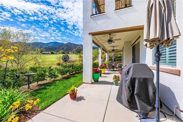 view of patio / terrace with a mountain view, outdoor dining area, and a ceiling fan