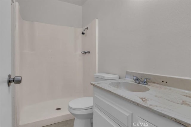 bathroom featuring toilet, a shower stall, and vanity