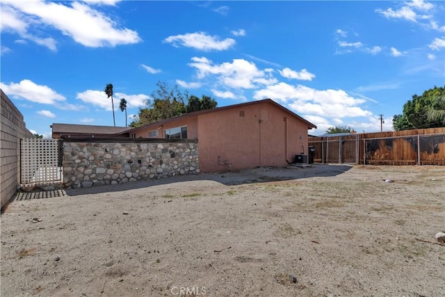 exterior space featuring central AC unit, fence, and stucco siding